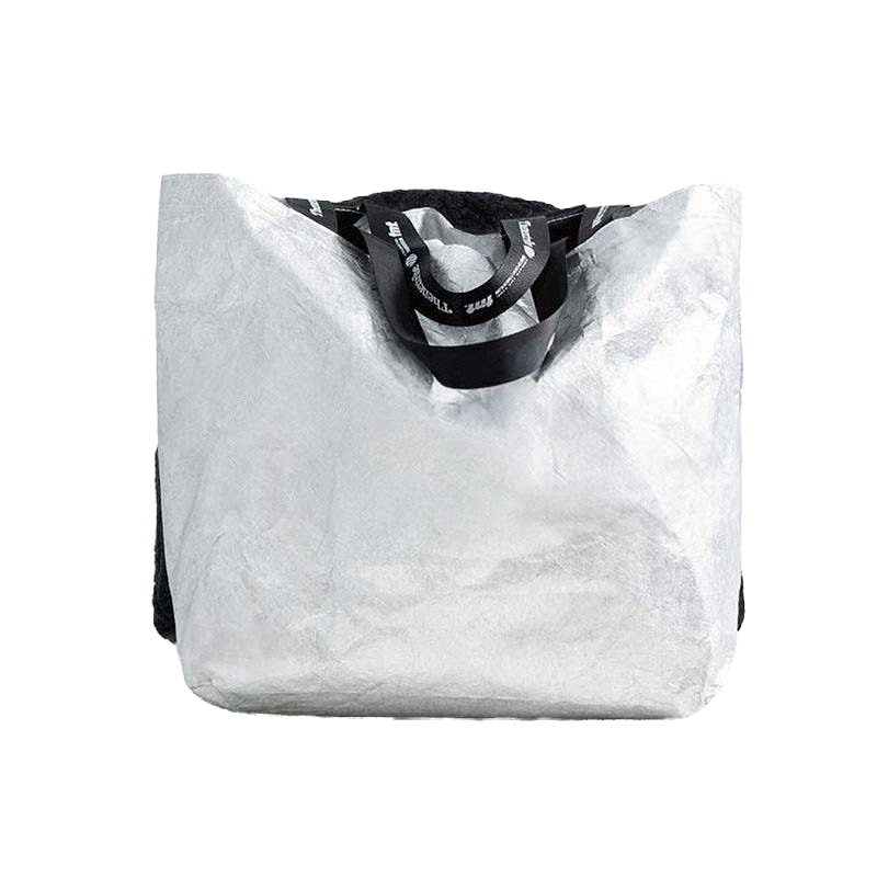 This image features a stylish tote bag, characterized by its large, open design with a sleek black handle. The tote is crafted from a textured white material that resembles faux fur, creating a chic and trendy appearance.