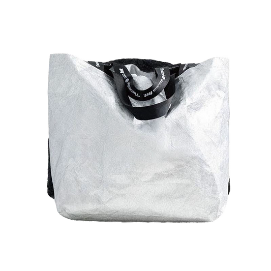 This image features a stylish tote bag, characterized by its large, open design with a sleek black handle. The tote is crafted from a textured white material that resembles faux fur, creating a chic and trendy appearance.